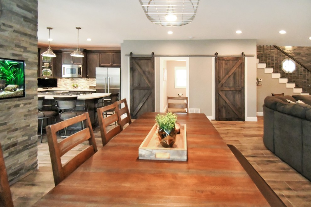 Diseño de comedor de estilo de casa de campo grande abierto con paredes grises y suelo marrón