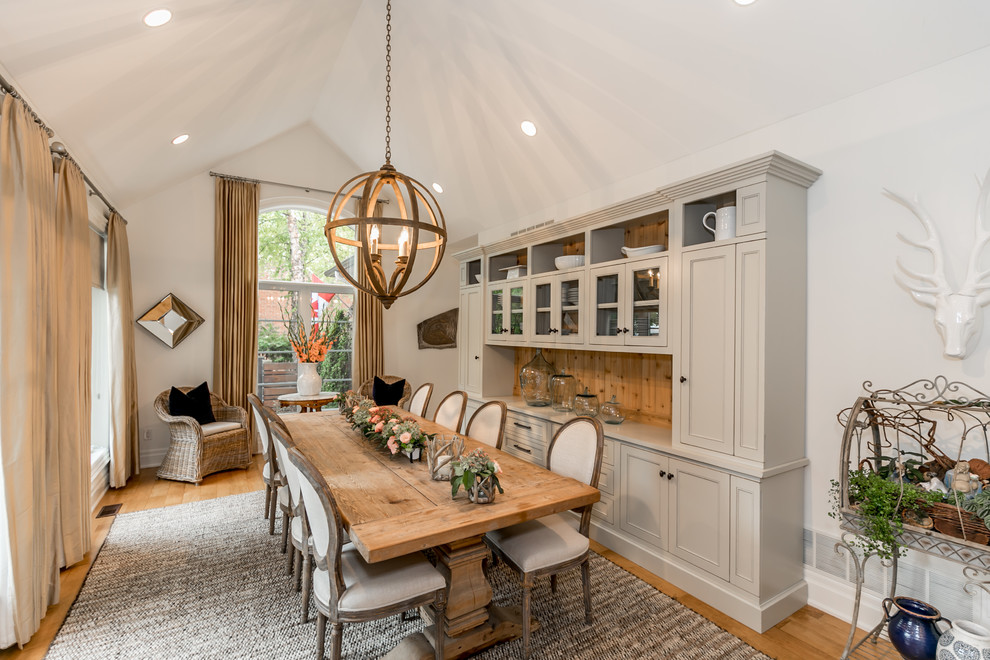 Large rural enclosed dining room in Toronto with white walls, medium hardwood flooring, no fireplace and brown floors.