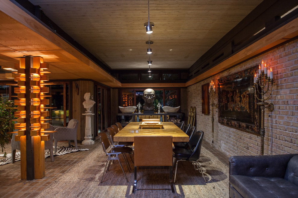 Foto di una grande sala da pranzo aperta verso il soggiorno bohémian con pareti beige e pavimento in legno massello medio