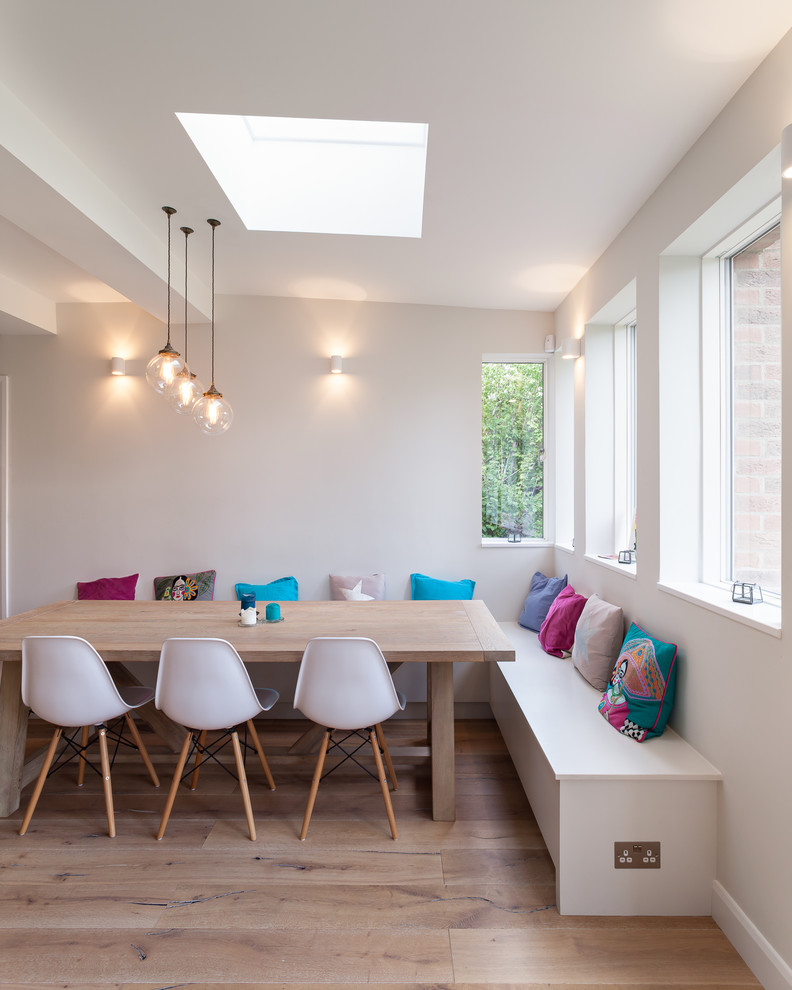 Große Moderne Wohnküche ohne Kamin mit braunem Holzboden und weißer Wandfarbe in London