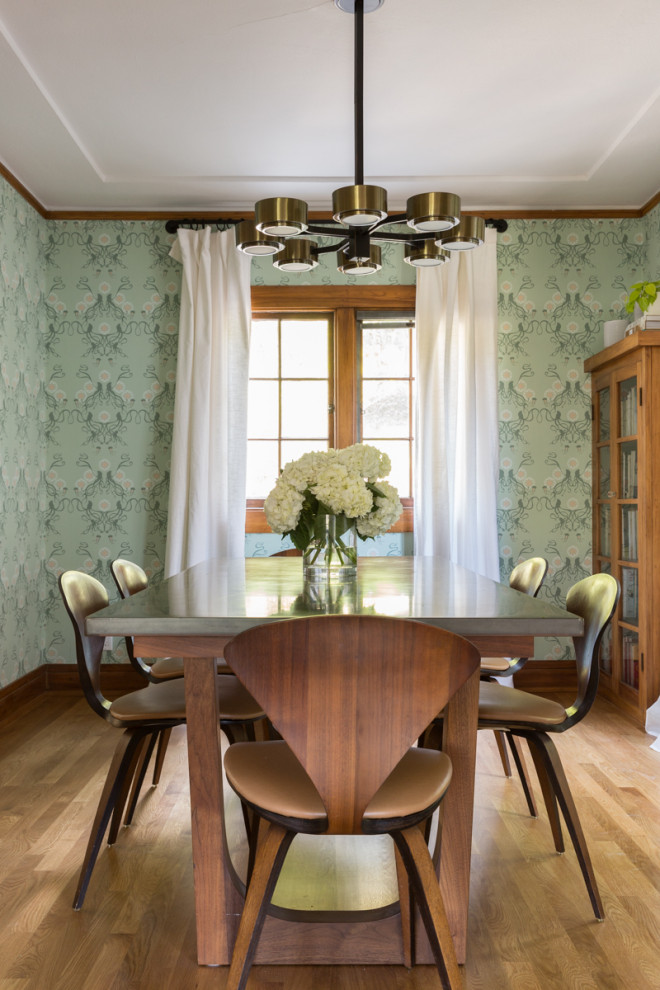 Cette photo montre une salle à manger tendance fermée et de taille moyenne avec un mur vert, un sol en bois brun et aucune cheminée.