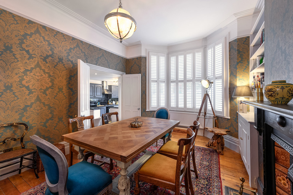 Medium sized traditional enclosed dining room in London with brown walls, medium hardwood flooring, a standard fireplace and brown floors.