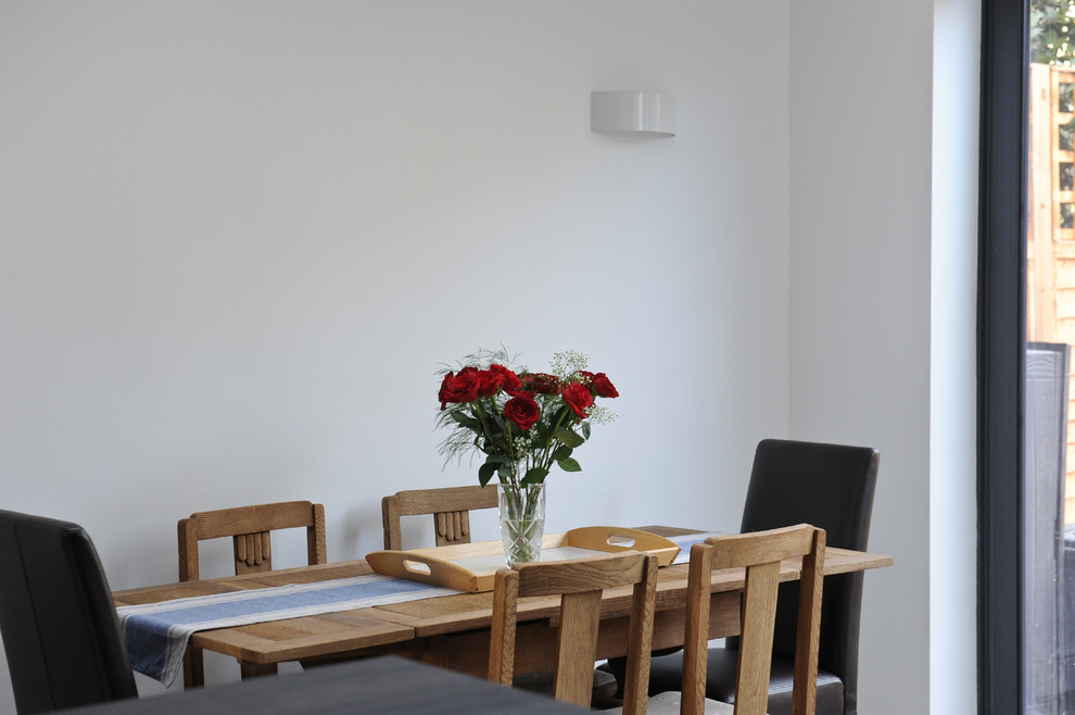 Diseño de comedor minimalista grande abierto con paredes blancas y suelo de baldosas de cerámica