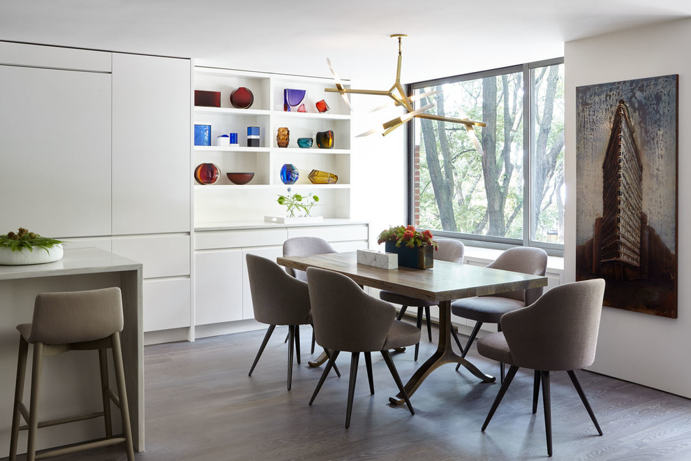 Idee per una piccola sala da pranzo aperta verso la cucina moderna con pareti bianche, pavimento in legno massello medio e pavimento marrone