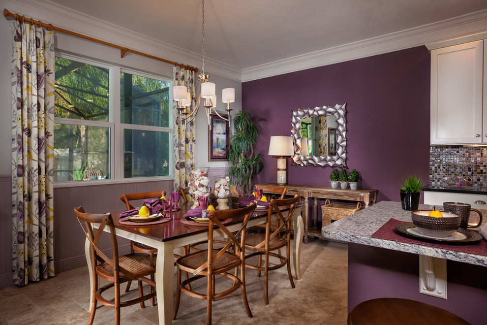 Imagen de comedor de cocina tropical con paredes púrpuras y suelo de travertino