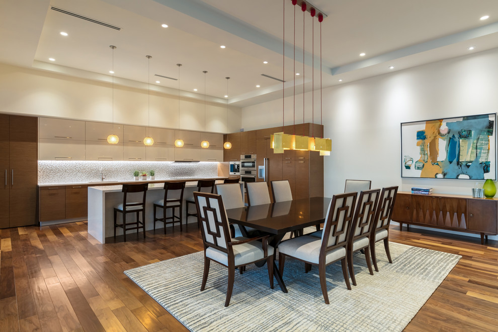 Foto di una grande sala da pranzo aperta verso il soggiorno contemporanea con pareti bianche, pavimento in legno massello medio e pavimento marrone