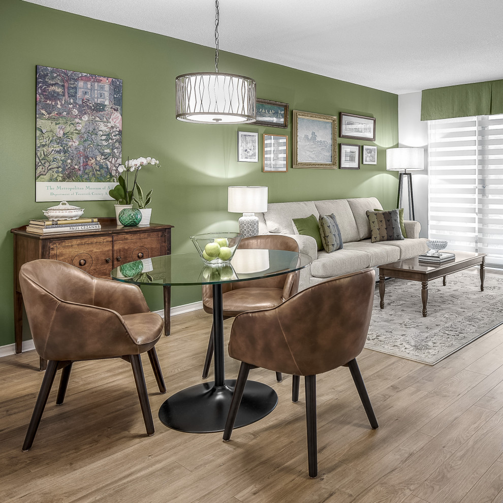 Immagine di una sala da pranzo aperta verso il soggiorno chic di medie dimensioni con pareti verdi, pavimento in legno massello medio e pavimento beige