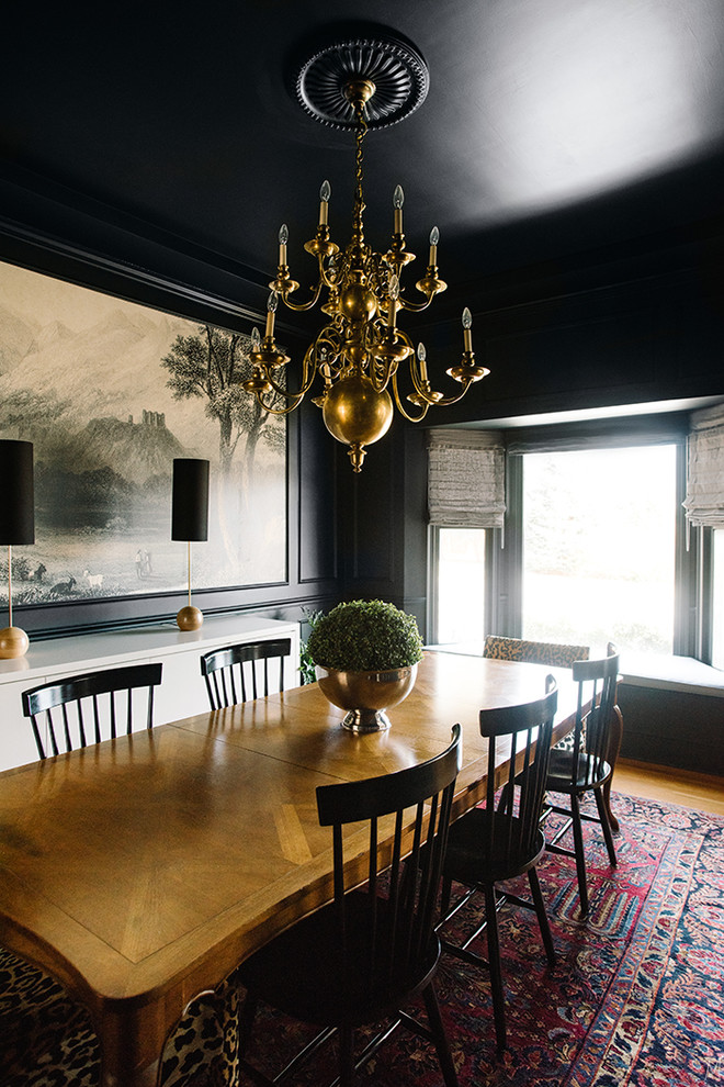Immagine di una grande sala da pranzo eclettica chiusa con pareti nere e parquet chiaro