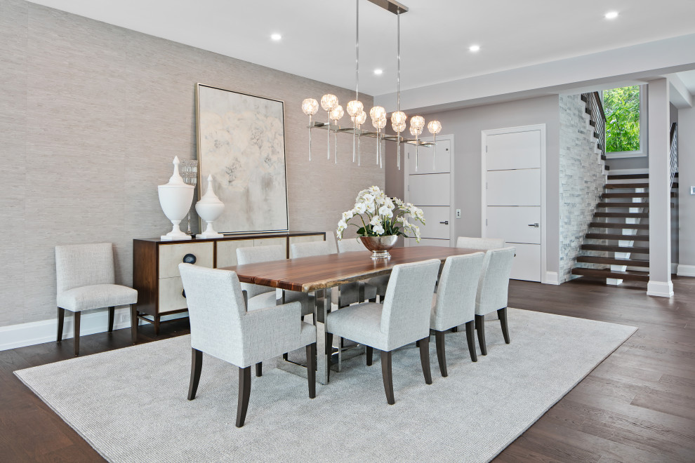 Inspiration for an expansive contemporary open plan dining room in Tampa with grey walls, dark hardwood flooring, a ribbon fireplace, a stone fireplace surround, brown floors and wallpapered walls.