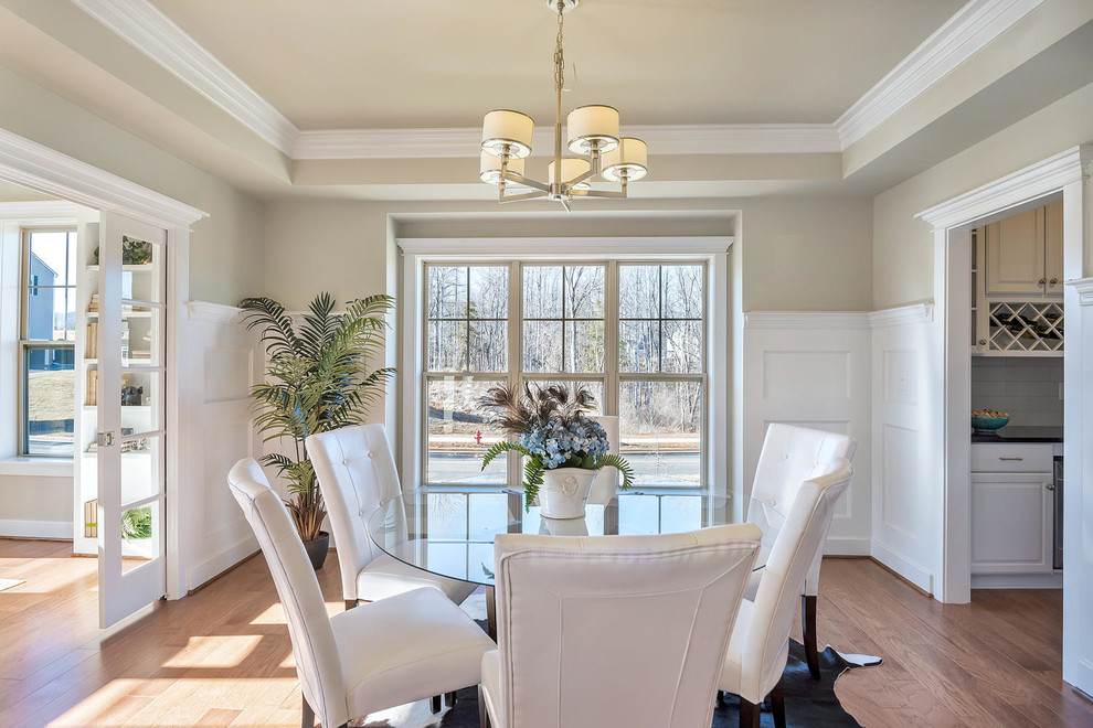 Foto di una sala da pranzo aperta verso il soggiorno american style di medie dimensioni con pareti beige e parquet chiaro