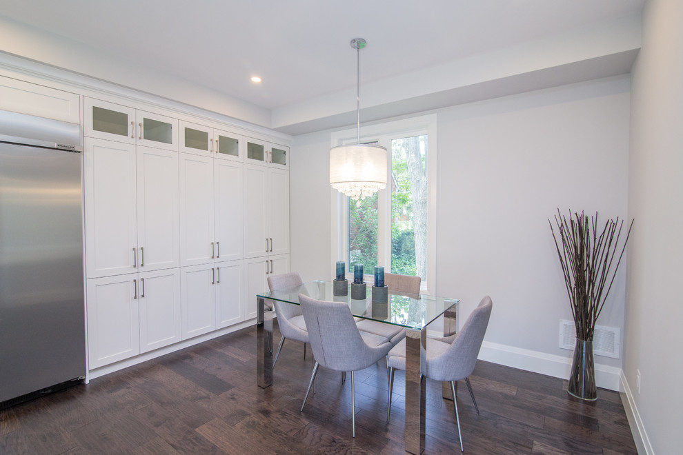 Example of a mid-sized arts and crafts medium tone wood floor and brown floor kitchen/dining room combo design in Toronto with beige walls and no fireplace