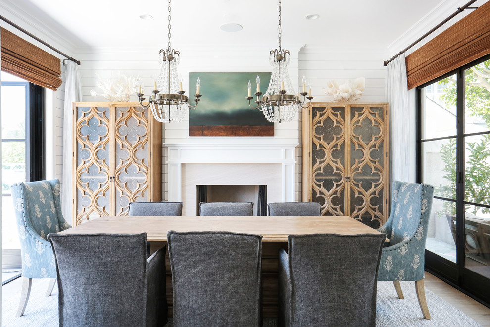 Geschlossenes, Mittelgroßes Maritimes Esszimmer mit weißer Wandfarbe, hellem Holzboden, Kamin und Kaminumrandung aus Stein in Orange County