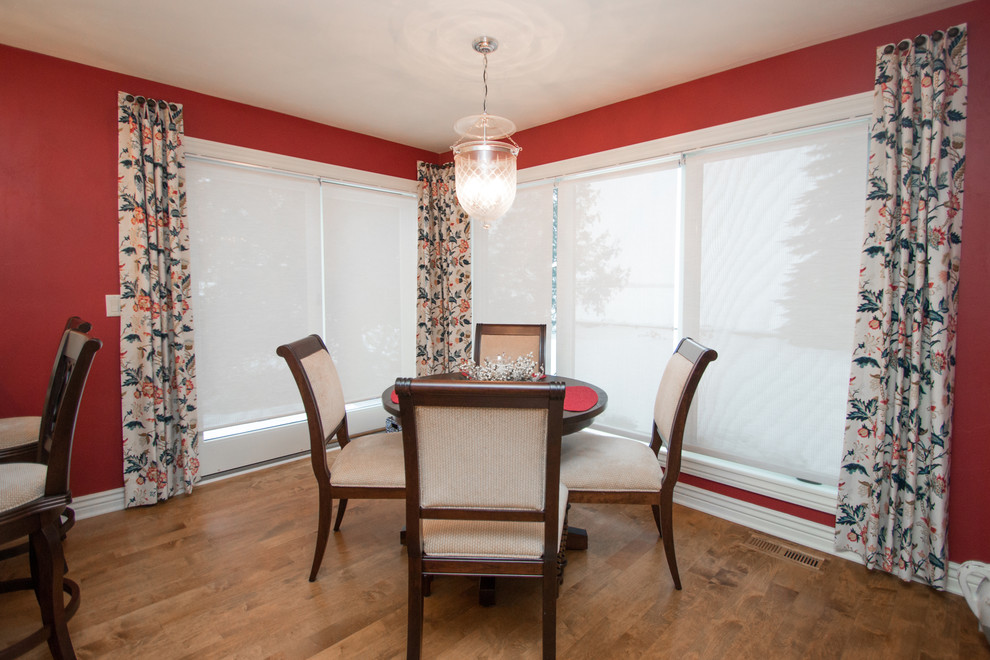Foto di una piccola sala da pranzo aperta verso la cucina classica con pareti rosse, pavimento in legno massello medio e nessun camino