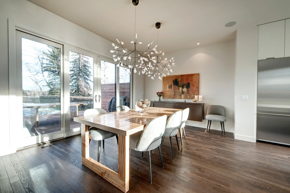 Esempio di una grande sala da pranzo aperta verso la cucina minimalista con pareti bianche e pavimento in legno massello medio