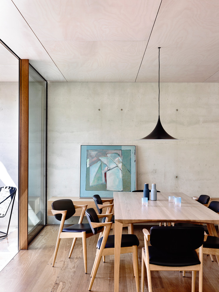 Idées déco pour une petite salle à manger ouverte sur la cuisine moderne avec un mur gris, un sol en bois brun et éclairage.