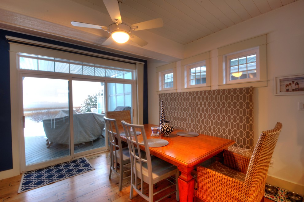 Cette image montre une salle à manger ouverte sur la cuisine traditionnelle de taille moyenne avec un mur bleu, un sol en bois brun, aucune cheminée et un sol marron.
