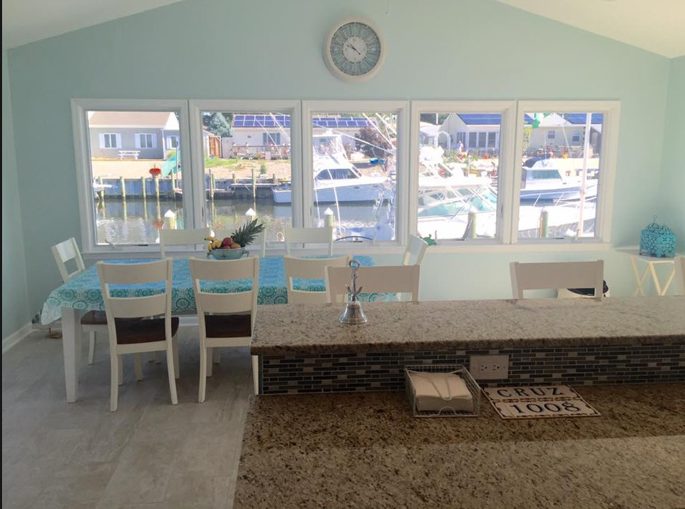 Ispirazione per una sala da pranzo aperta verso la cucina stile marino di medie dimensioni con pareti blu, pavimento in laminato, nessun camino e pavimento grigio