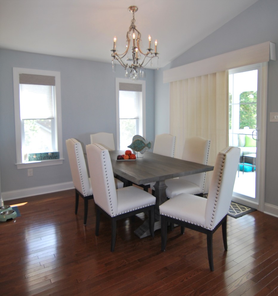 Cette image montre une salle à manger ouverte sur le salon marine de taille moyenne avec un mur bleu, un sol en bois brun et un sol marron.