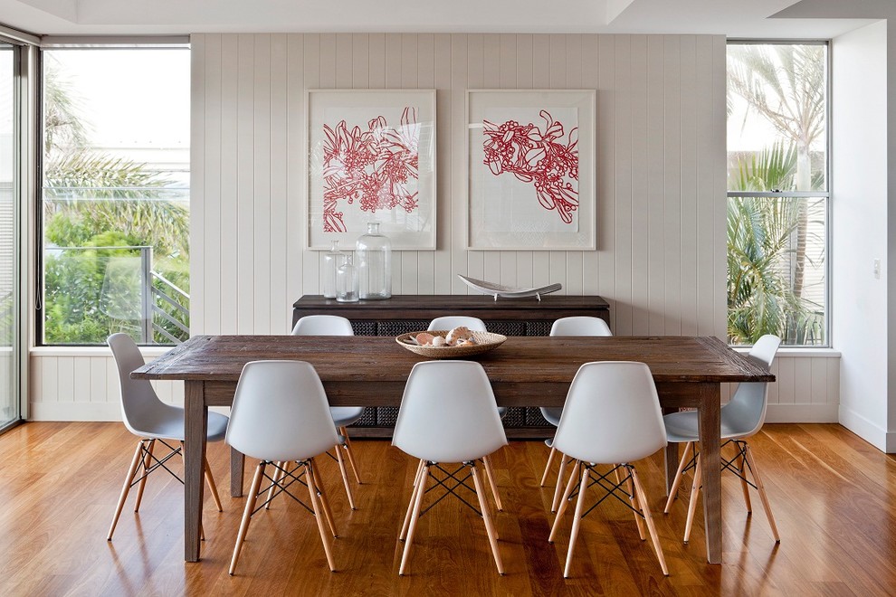 Diseño de comedor contemporáneo con suelo de madera en tonos medios, paredes beige y cuadros
