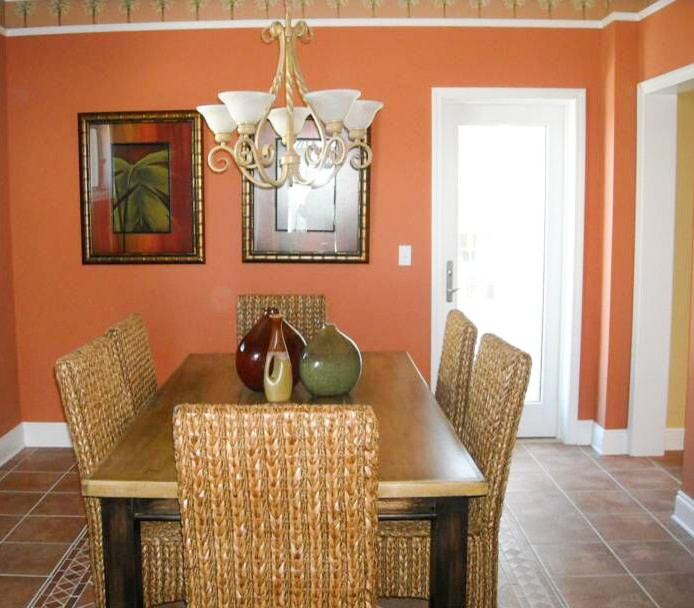 Ispirazione per una sala da pranzo tropicale chiusa e di medie dimensioni con pareti arancioni e pavimento in terracotta