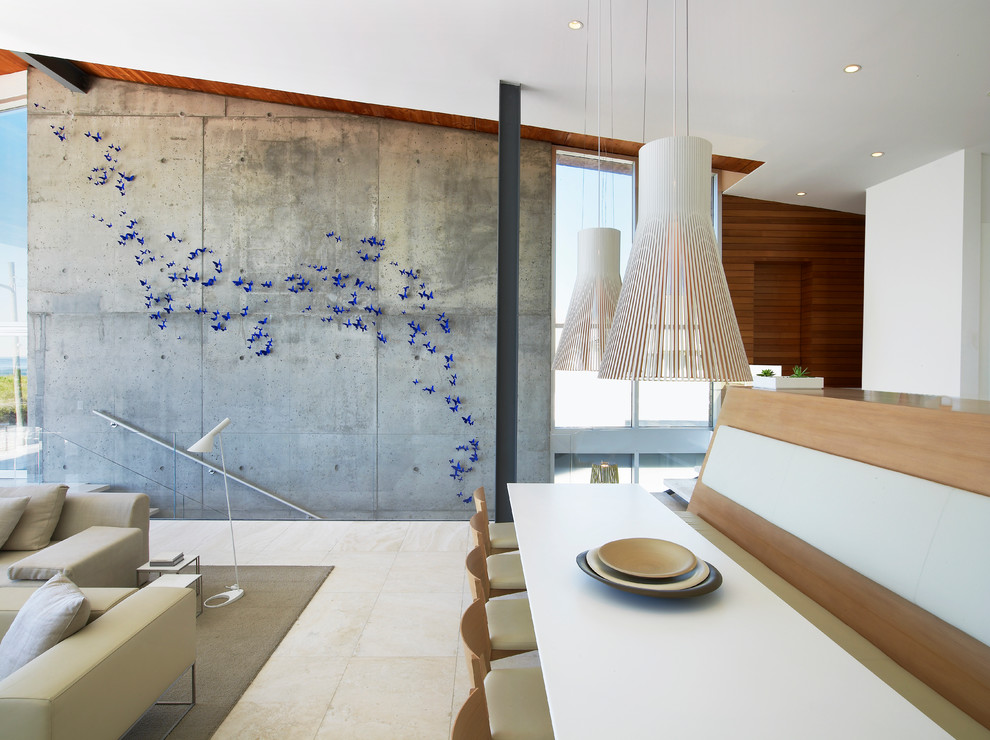 Cette image montre une salle à manger ouverte sur le salon minimaliste avec un mur blanc et éclairage.