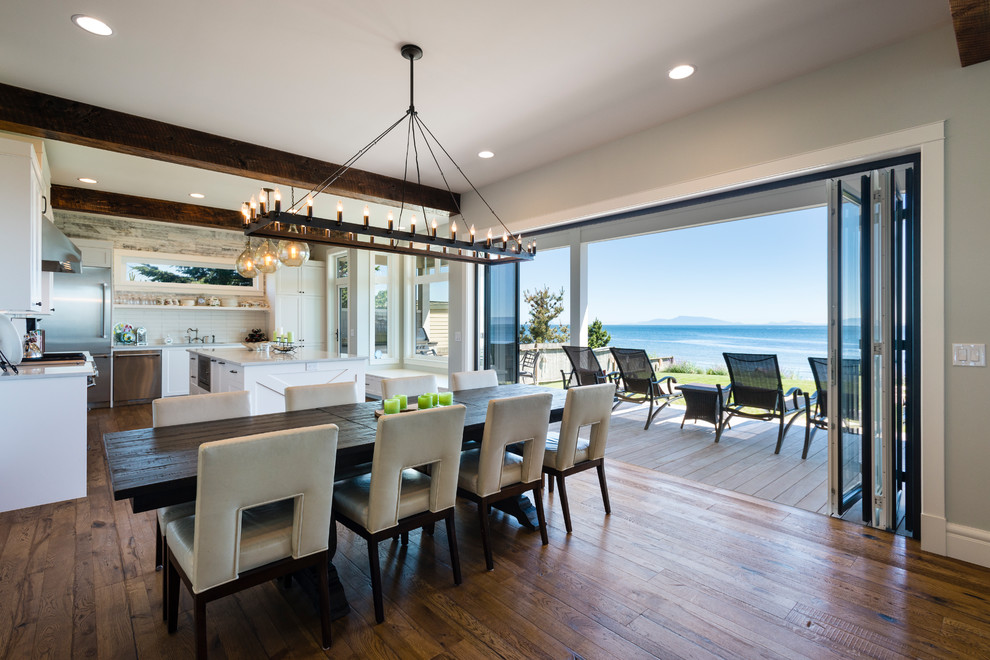 Esempio di una sala da pranzo aperta verso il soggiorno costiera di medie dimensioni con pareti grigie, pavimento in legno massello medio e pavimento marrone