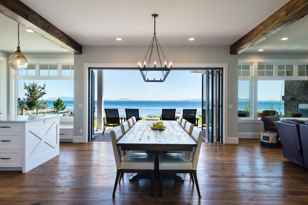 Esempio di una sala da pranzo aperta verso il soggiorno stile marino di medie dimensioni con pareti grigie, pavimento in legno massello medio e pavimento marrone