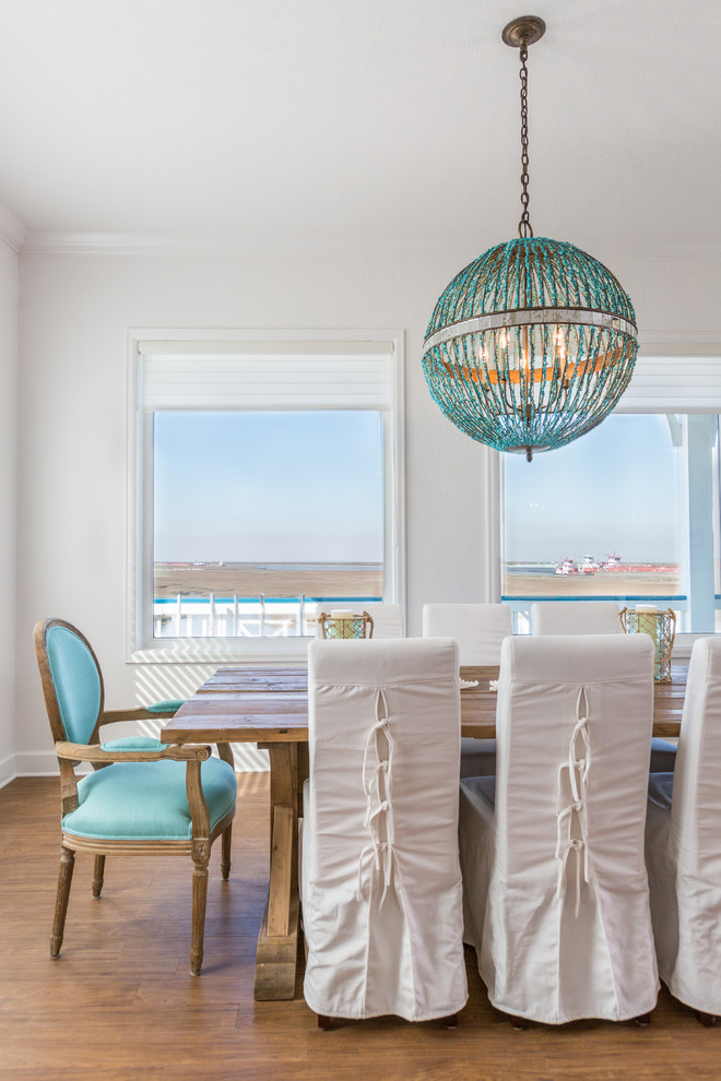 Beach style open plan dining room in Houston with white walls.