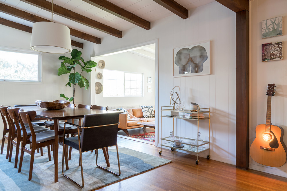 Esempio di una grande sala da pranzo aperta verso il soggiorno stile marino con pareti bianche, pavimento in legno massello medio e pavimento marrone