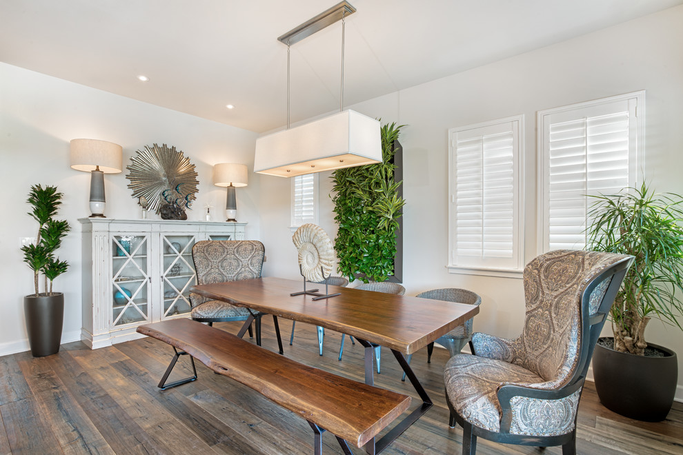 Inspiration for a beach style enclosed dining room in Phoenix with white walls, medium hardwood flooring, brown floors and feature lighting.