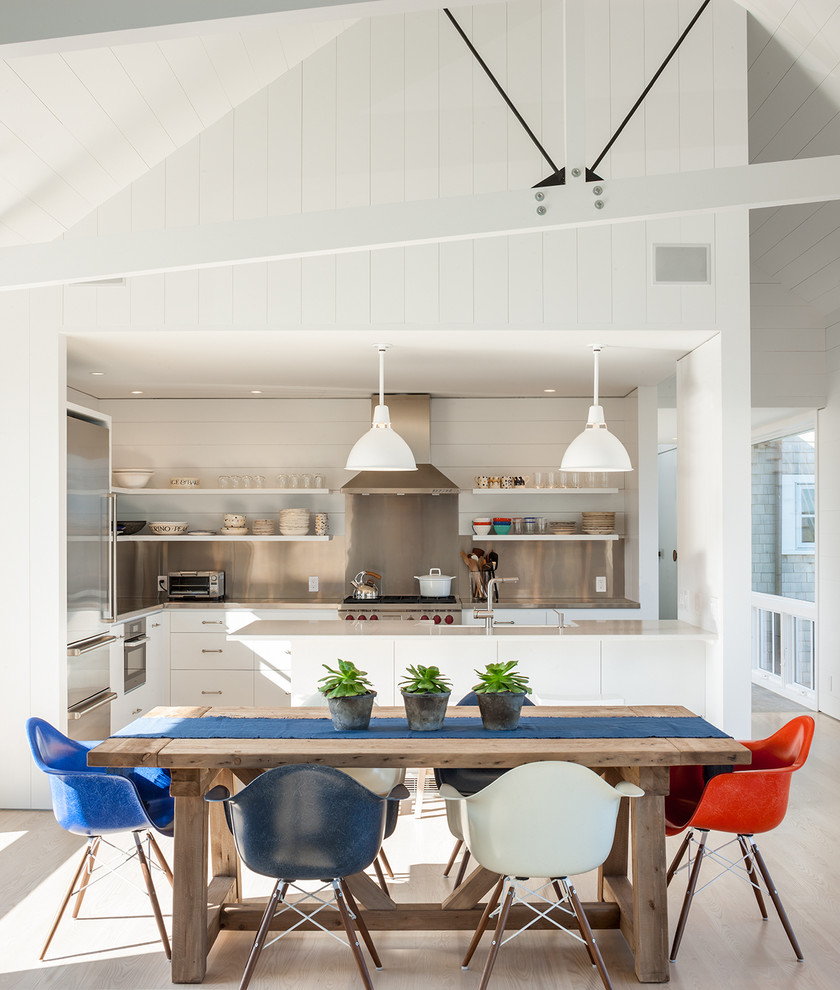 Ispirazione per una sala da pranzo aperta verso la cucina stile marino di medie dimensioni con pareti bianche e parquet chiaro