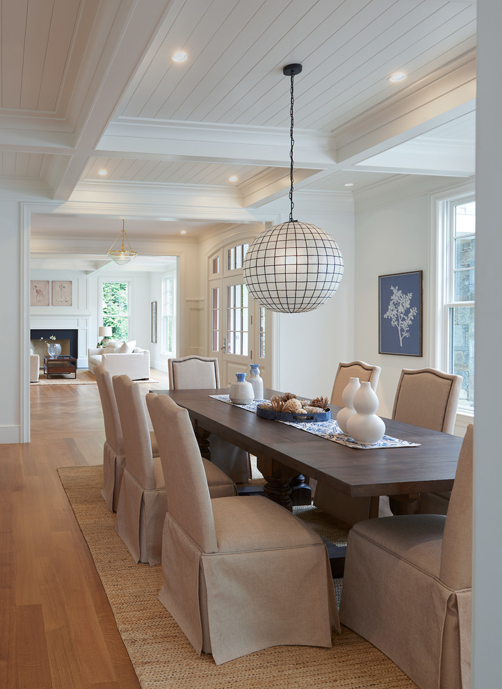 Esempio di una sala da pranzo aperta verso il soggiorno costiera con pareti bianche, pavimento in legno massello medio e pavimento beige