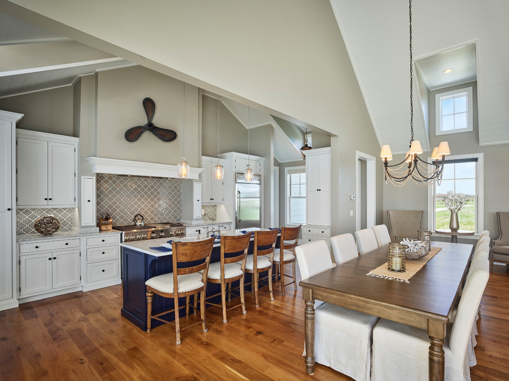 Inspiration pour une salle à manger ouverte sur la cuisine marine de taille moyenne avec un mur gris et un sol en bois brun.