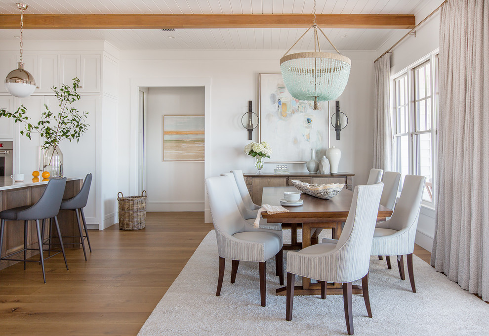 Esempio di una grande sala da pranzo aperta verso il soggiorno stile marinaro con pareti bianche, pavimento in legno massello medio e pavimento marrone