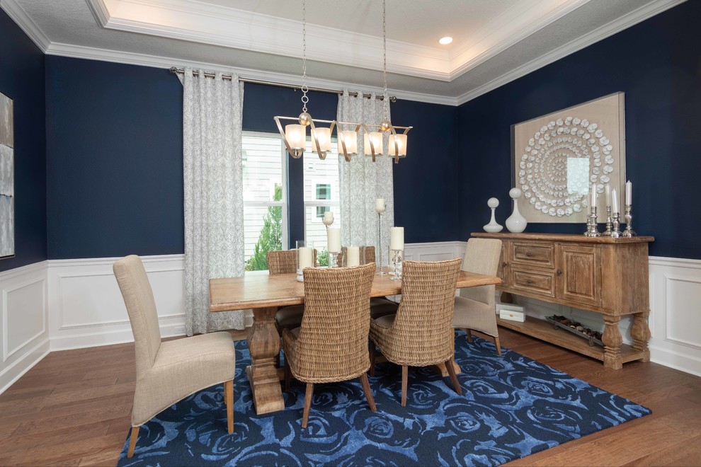 Diseño de comedor costero sin chimenea con paredes azules, suelo de madera en tonos medios y cortinas