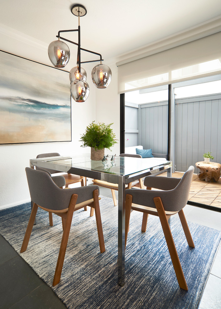 This is an example of a contemporary enclosed dining room in Los Angeles with white walls and grey floors.