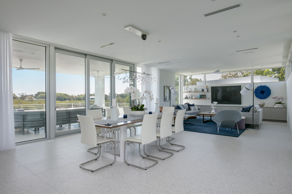 На фото: большая гостиная-столовая в морском стиле с белыми стенами, бетонным полом и разноцветным полом без камина