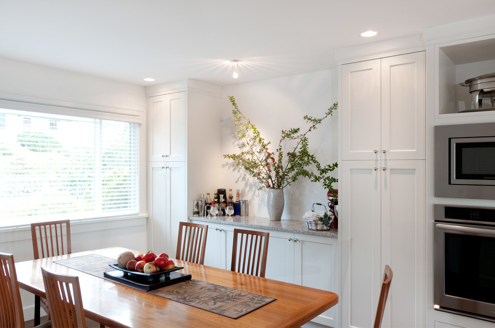 Идея дизайна: кухня-столовая среднего размера в стиле неоклассика (современная классика) с белыми стенами и темным паркетным полом