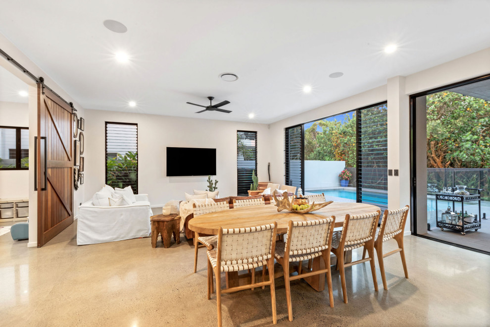 Offenes Modernes Esszimmer mit weißer Wandfarbe, Betonboden und grauem Boden in Sunshine Coast