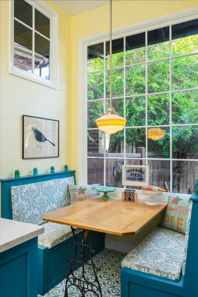 Cette image montre une salle à manger ouverte sur la cuisine traditionnelle de taille moyenne avec un sol bleu, un mur jaune et un sol en carrelage de céramique.