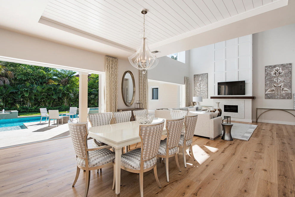 Design ideas for a classic open plan dining room in Miami with grey walls and light hardwood flooring.