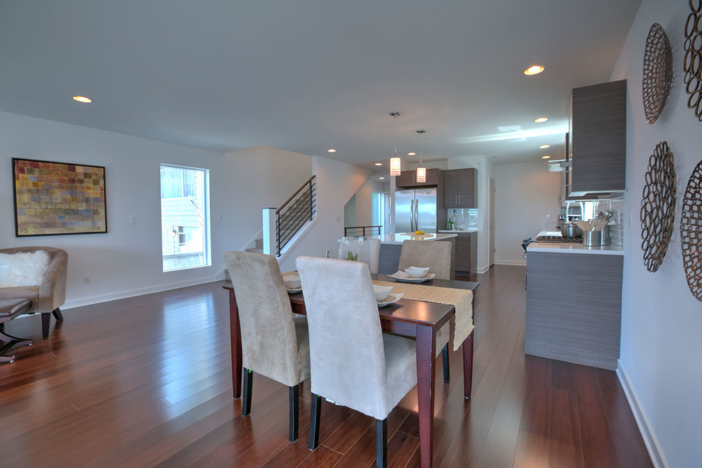 Immagine di una piccola sala da pranzo aperta verso la cucina design con pareti bianche, pavimento in bambù e pavimento marrone