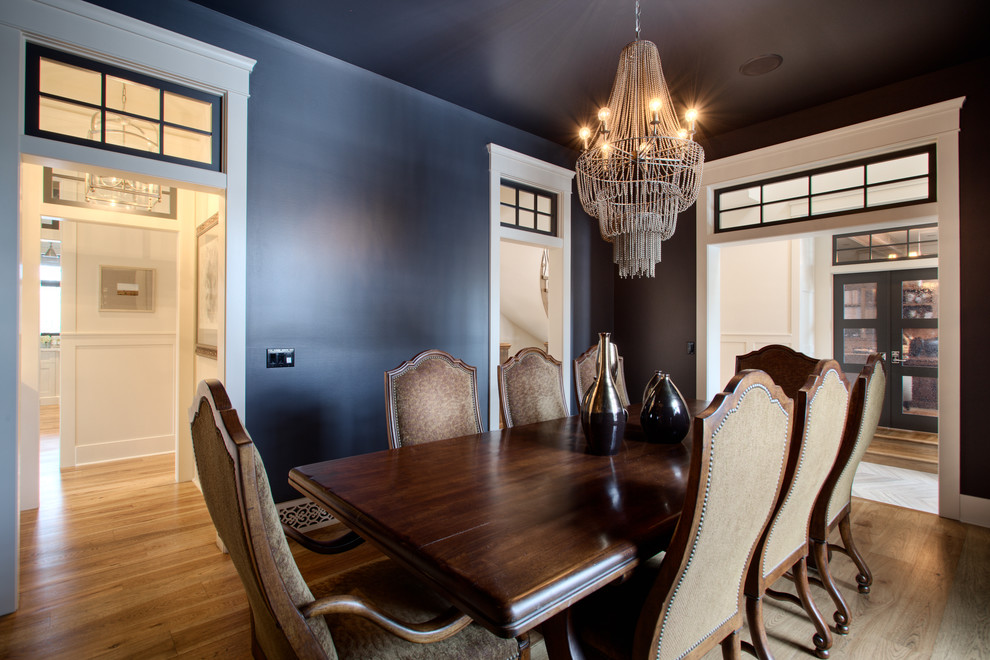 Exemple d'une petite salle à manger chic fermée avec un mur bleu et un sol en bois brun.