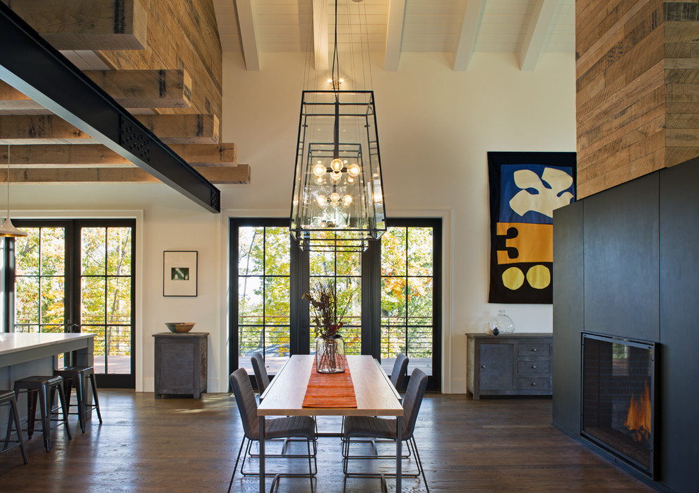 Large farmhouse open plan dining room in Other with white walls, dark hardwood flooring and a two-sided fireplace.