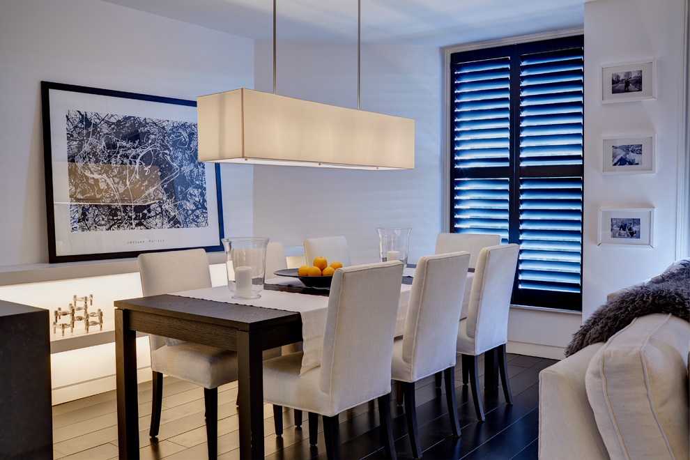 Idee per una sala da pranzo aperta verso la cucina minimal di medie dimensioni con pareti bianche, parquet scuro e camino classico