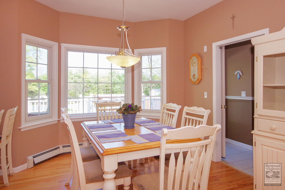 На фото: кухня-столовая среднего размера в стиле кантри с розовыми стенами и паркетным полом среднего тона без камина с