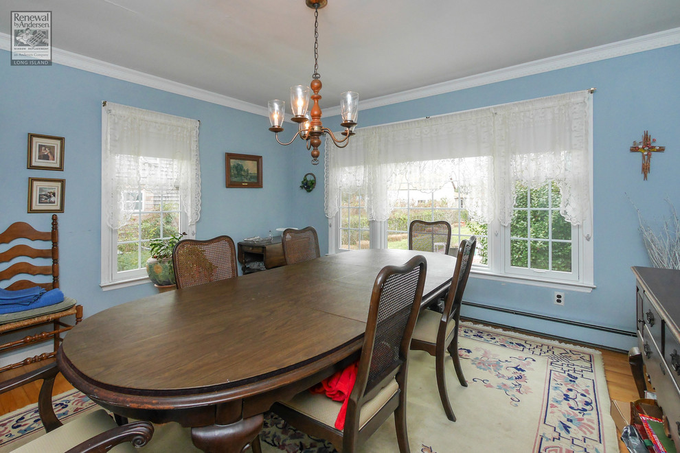 Immagine di una sala da pranzo tradizionale chiusa e di medie dimensioni con pareti blu, pavimento in legno massello medio e nessun camino