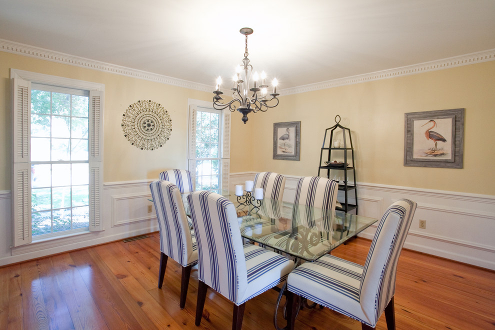 Klassisches Esszimmer mit beiger Wandfarbe und braunem Holzboden in Charleston