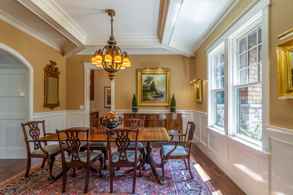 This is an example of a traditional dining room in Charlotte with yellow walls, dark hardwood flooring and brown floors.