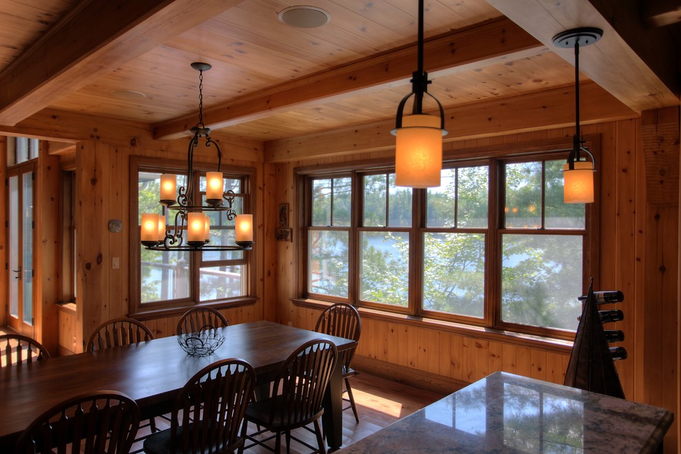 Idées déco pour une grande salle à manger ouverte sur la cuisine montagne avec un mur marron, un sol en bois brun et aucune cheminée.